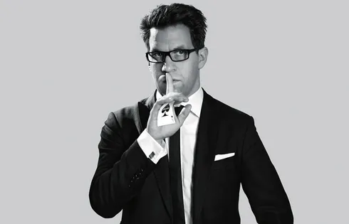 Maik M. Paulsen posiert mit Brille und Ass im Ärmel.