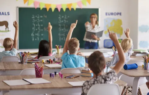 Symbolbild von Kindern, die sich in der Schule melden.
