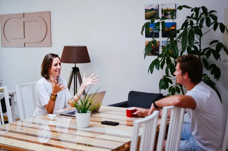 Anja und Axel kommunizieren im Büro zu Vertriebsthemen.