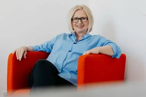 Michl Group-Gründerin Christa Koslitz sitzt in einem sessel.