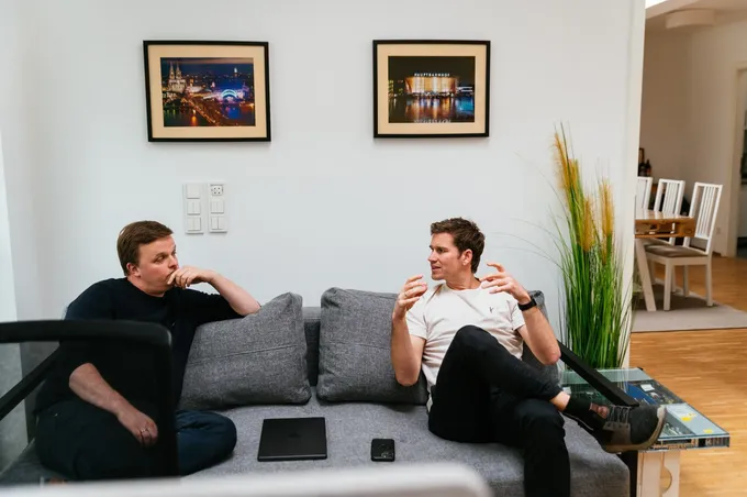 Axel und Christian führen ein Gespräch auf der Couch.